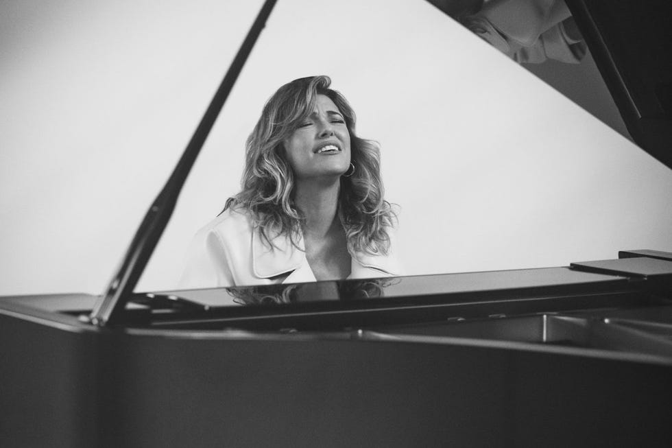 a musician seated at a grand piano exuding a serene and introspective atmosphere