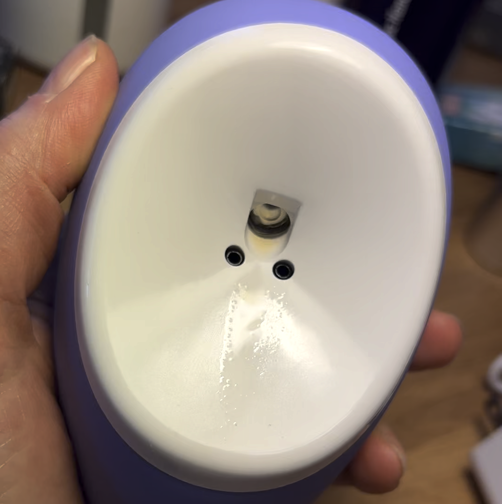 purple droplette skincare device being held in someone's hand