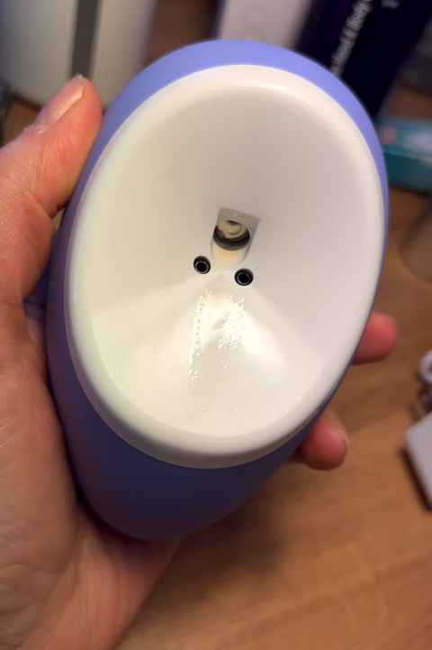 purple droplette skincare device being held in someone's hand