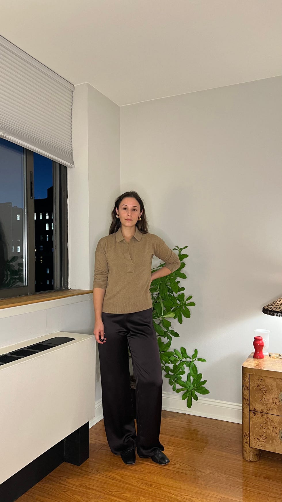 person standing in a modern living space with plants and furniture