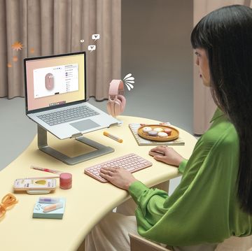 a person sitting at a table with a laptop and a plate of food
