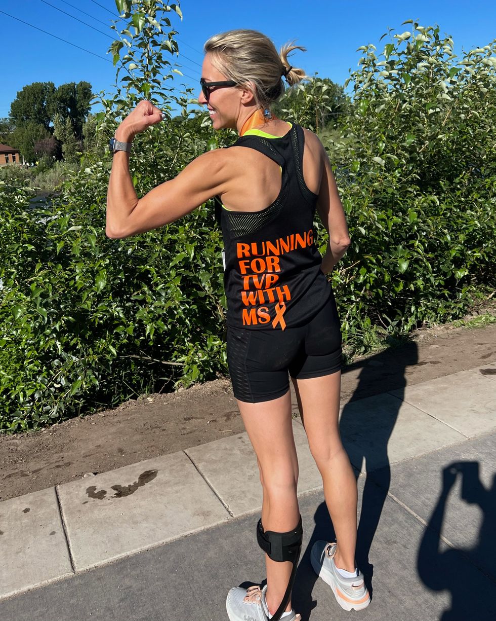 a woman wearing running clothes flexes her bicep