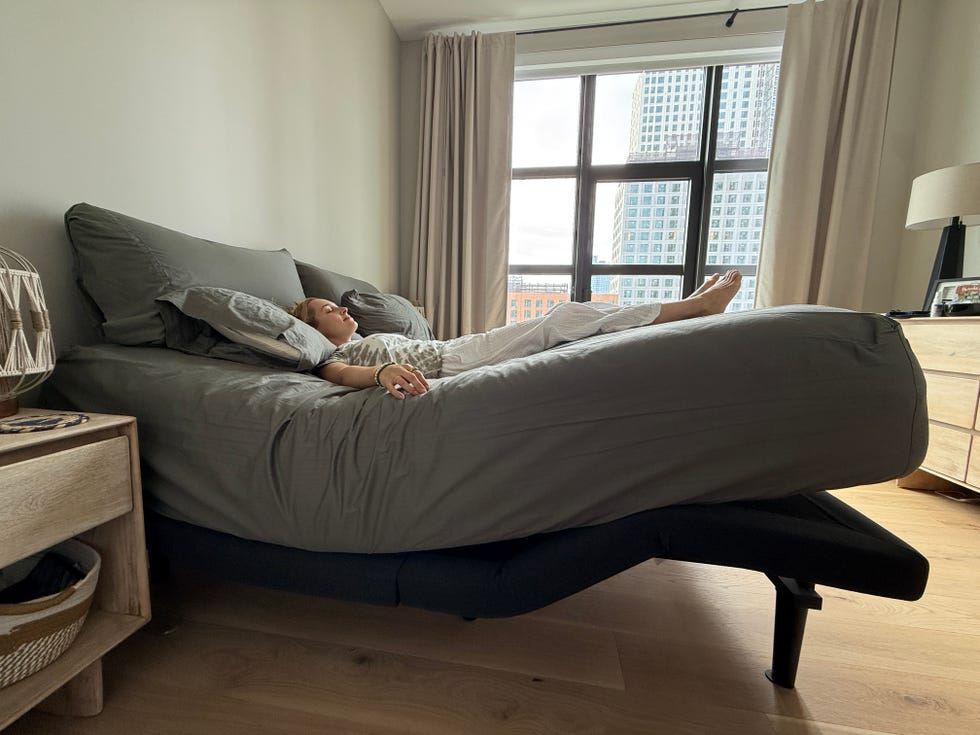 a woman resting on a mattress and adjustable bed in a zero gravity position