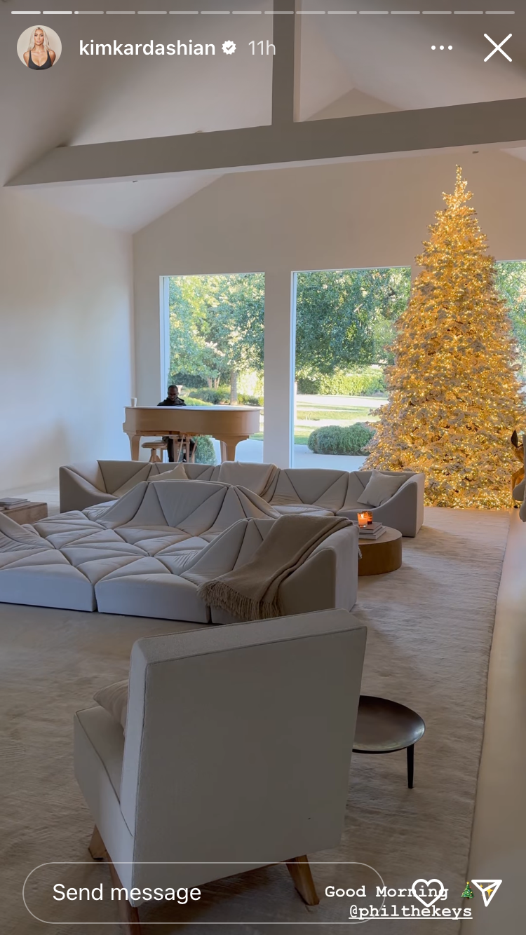 a room with a couch and a table with a tree in the background