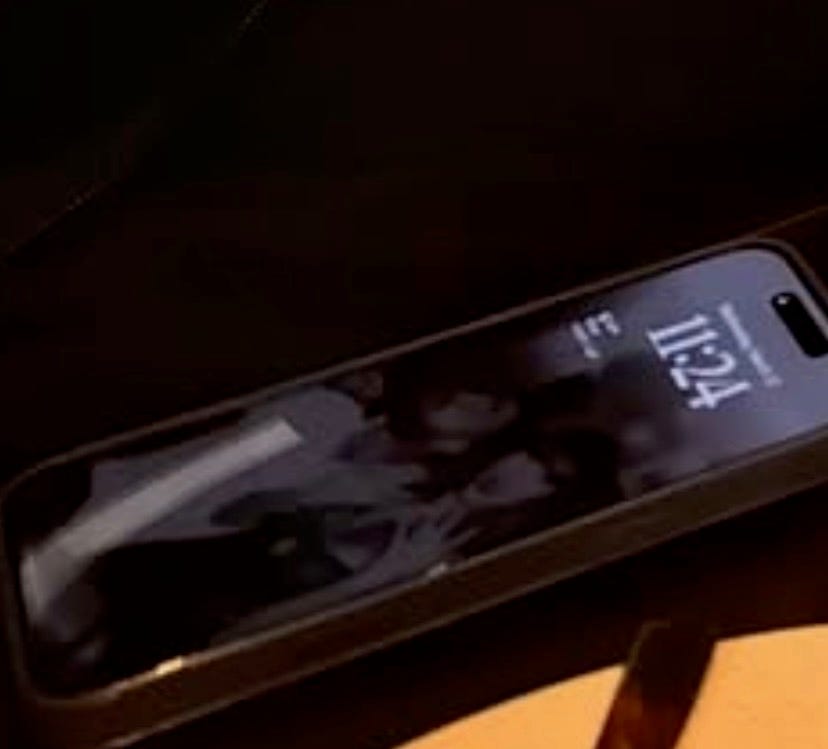 smartphone displaying time and wallpaper with a group photo
