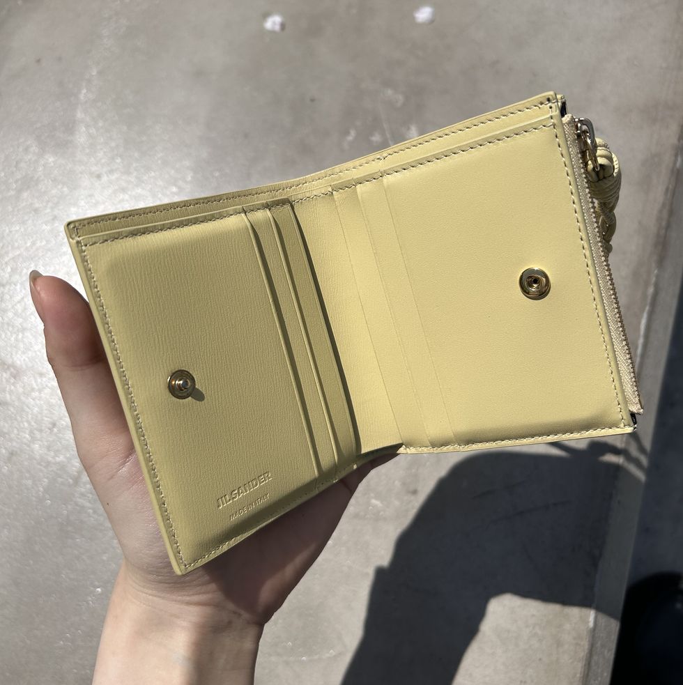 a hand holding a brown leather wallet