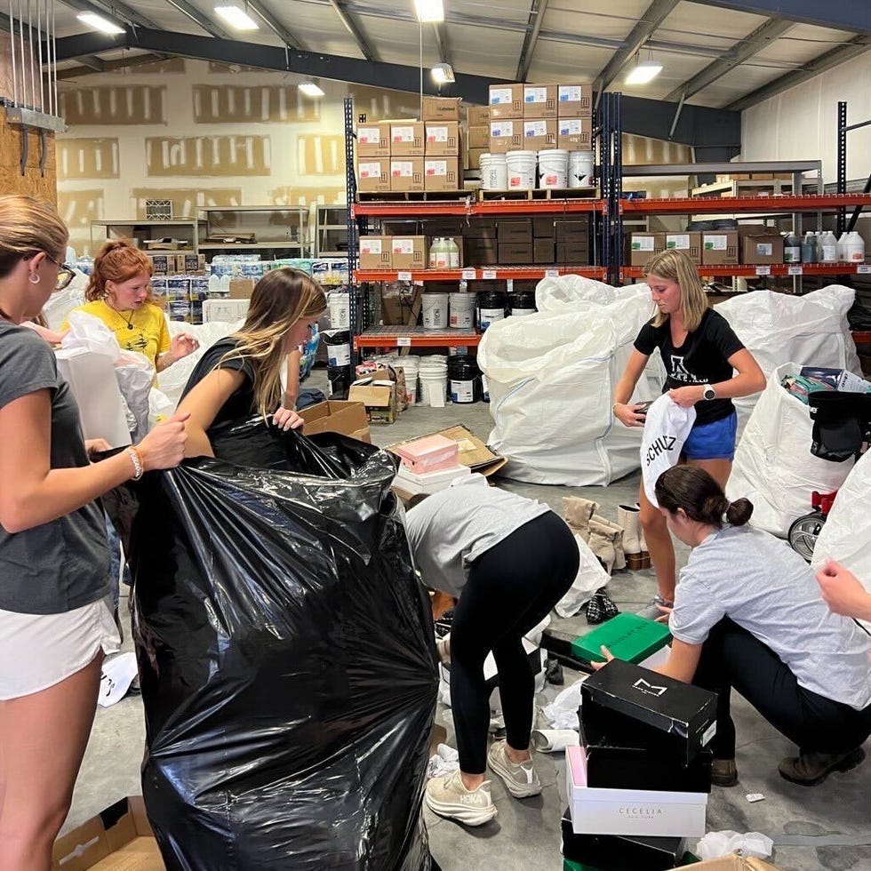 several individuals are actively engaged in sorting and organizing items in a warehouse like environment