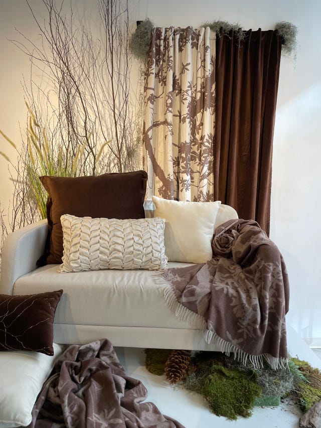cozy seating area with textured pillows and throws surrounded by natural elements