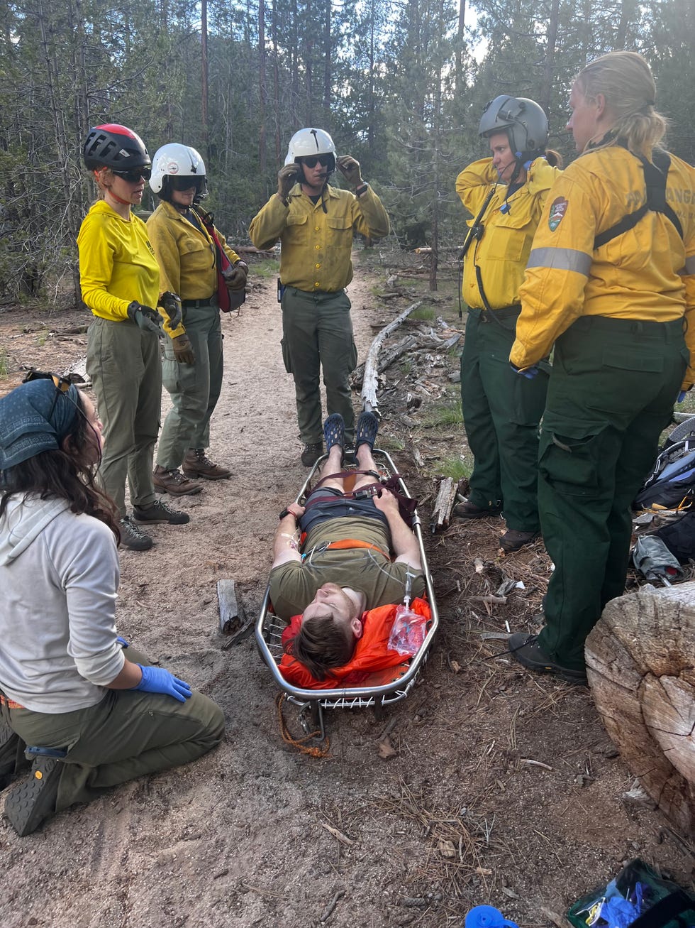 rescue team assisting Matthew Stewart on a trail