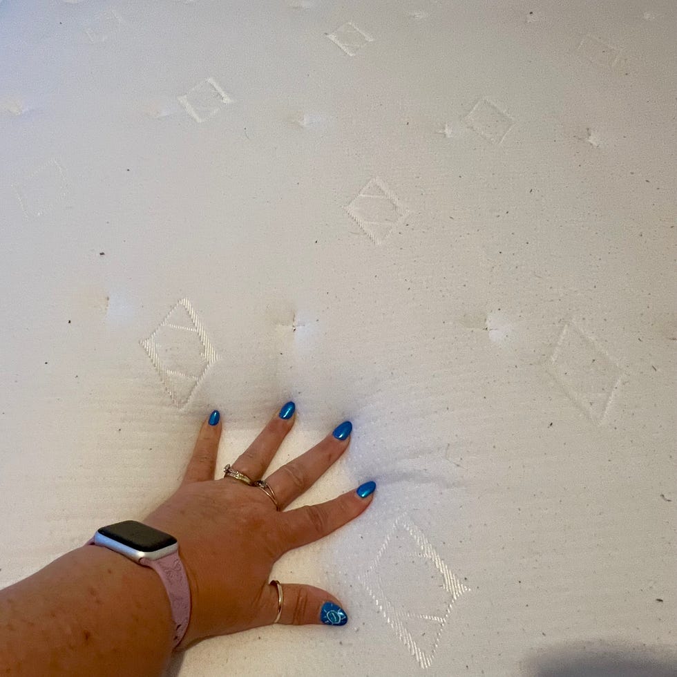 a person's hand touching the surface of the allswell luxe hybrid mattress