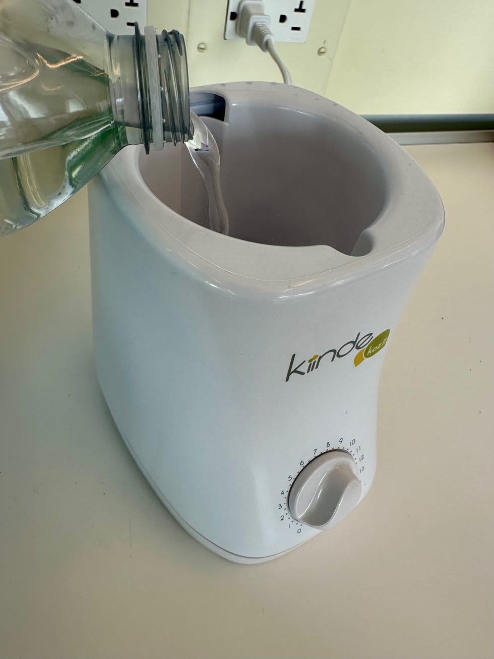 a good housekeeping institute lab pro fills a kiinde baby bottle warmer with water, testing for a list of the best bottle warmers