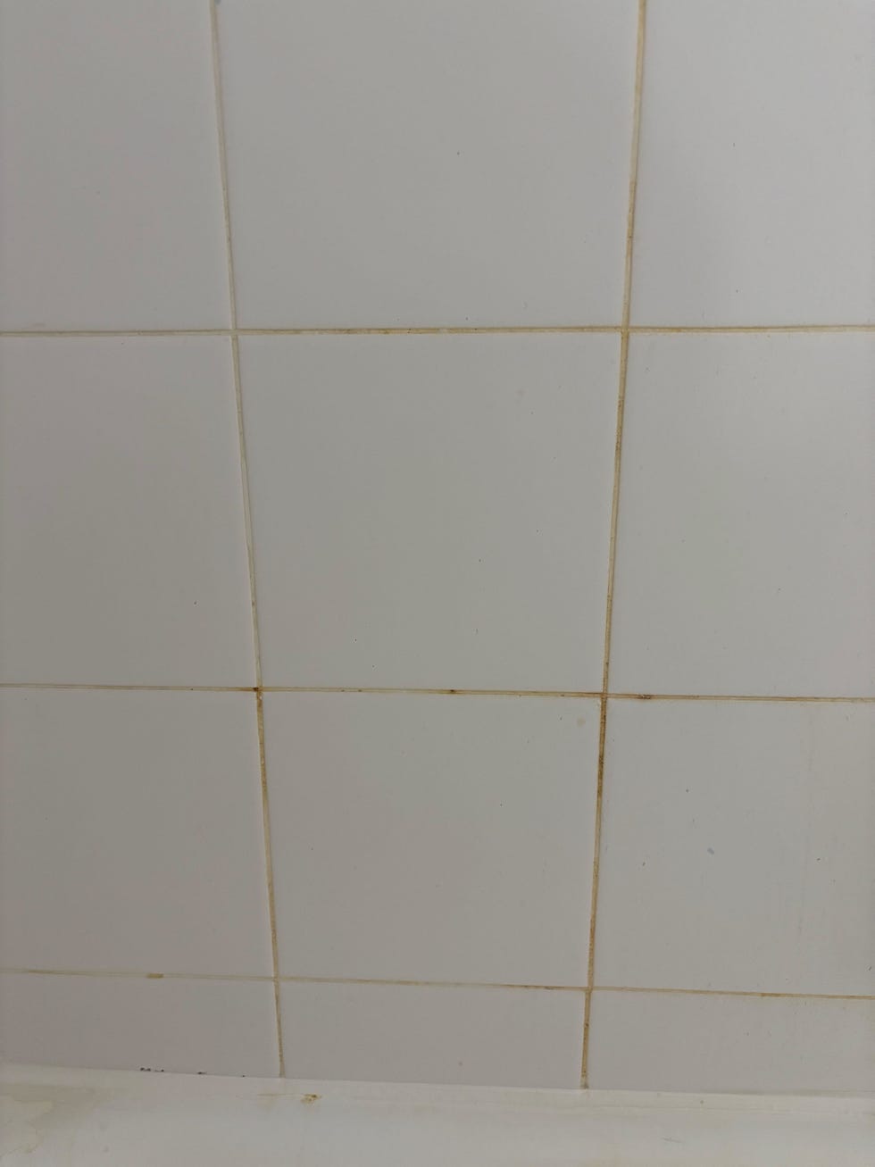 dirty bathroom tiles with noticeable stains and discoloration