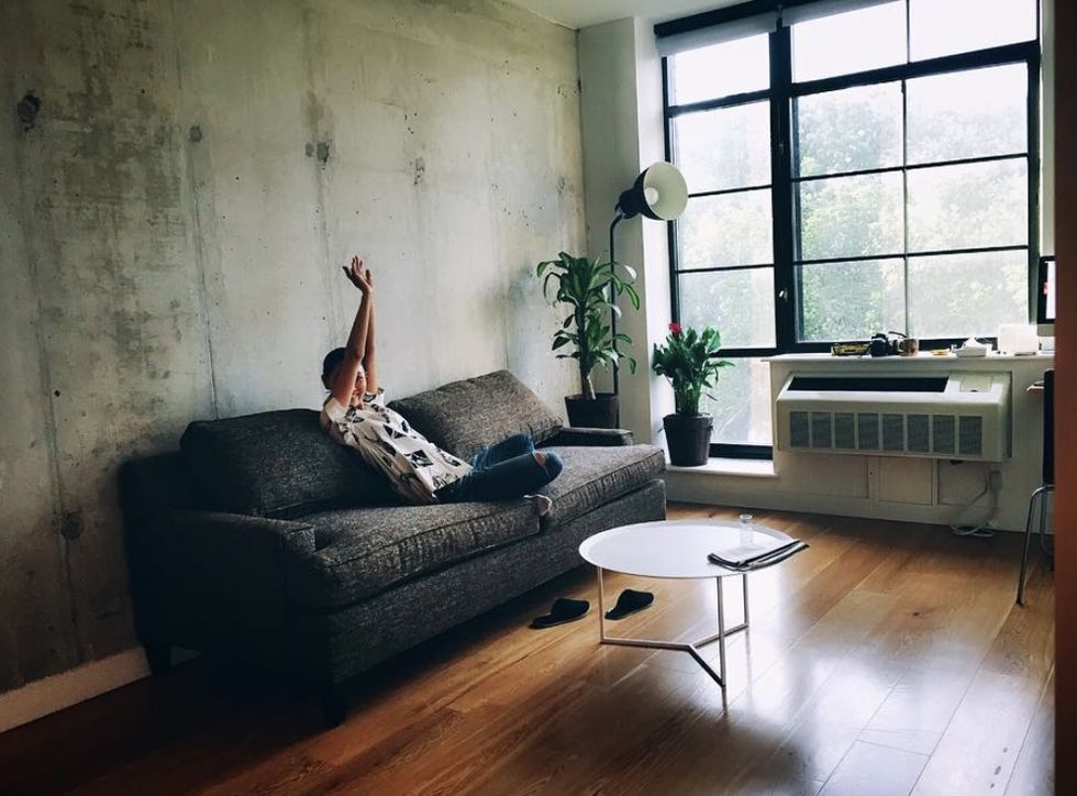 a person doing a handstand on a couch in a room
