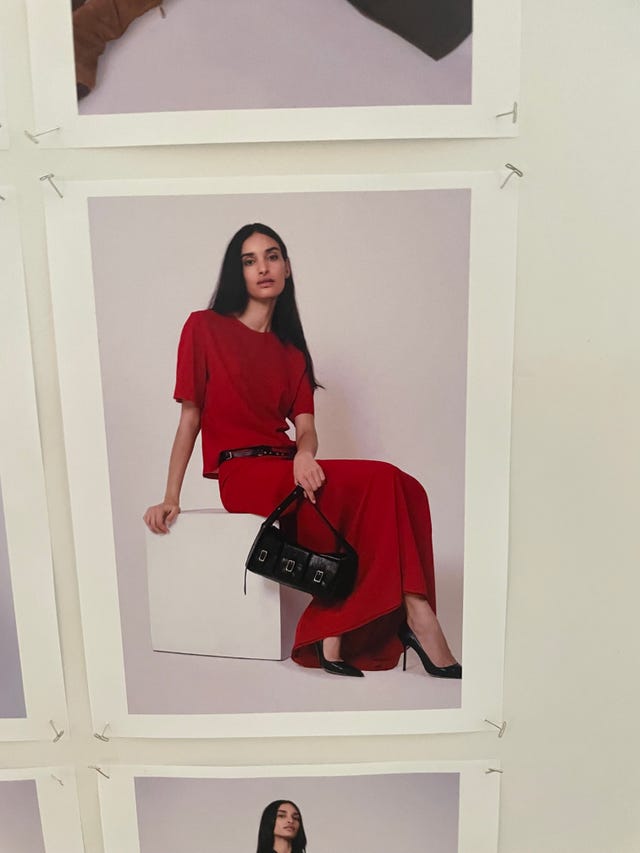 fashion model in a red outfit with a black handbag