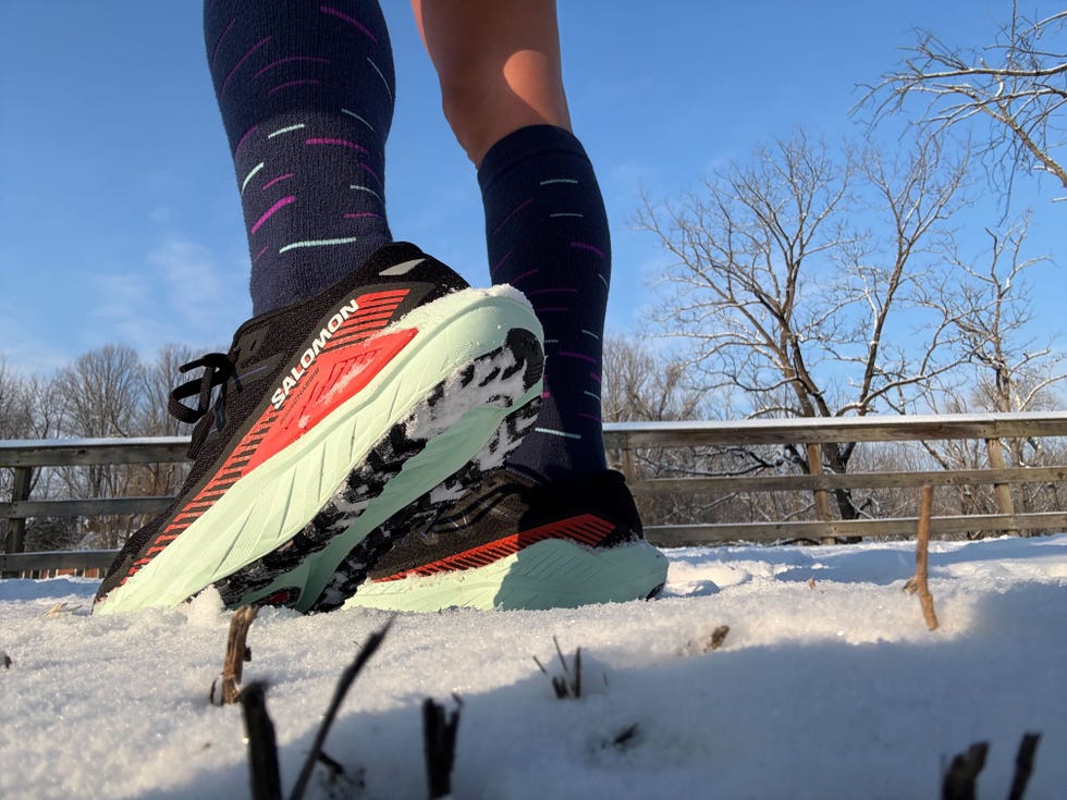 running shoes with distinctive branding and socks in snowy terrain