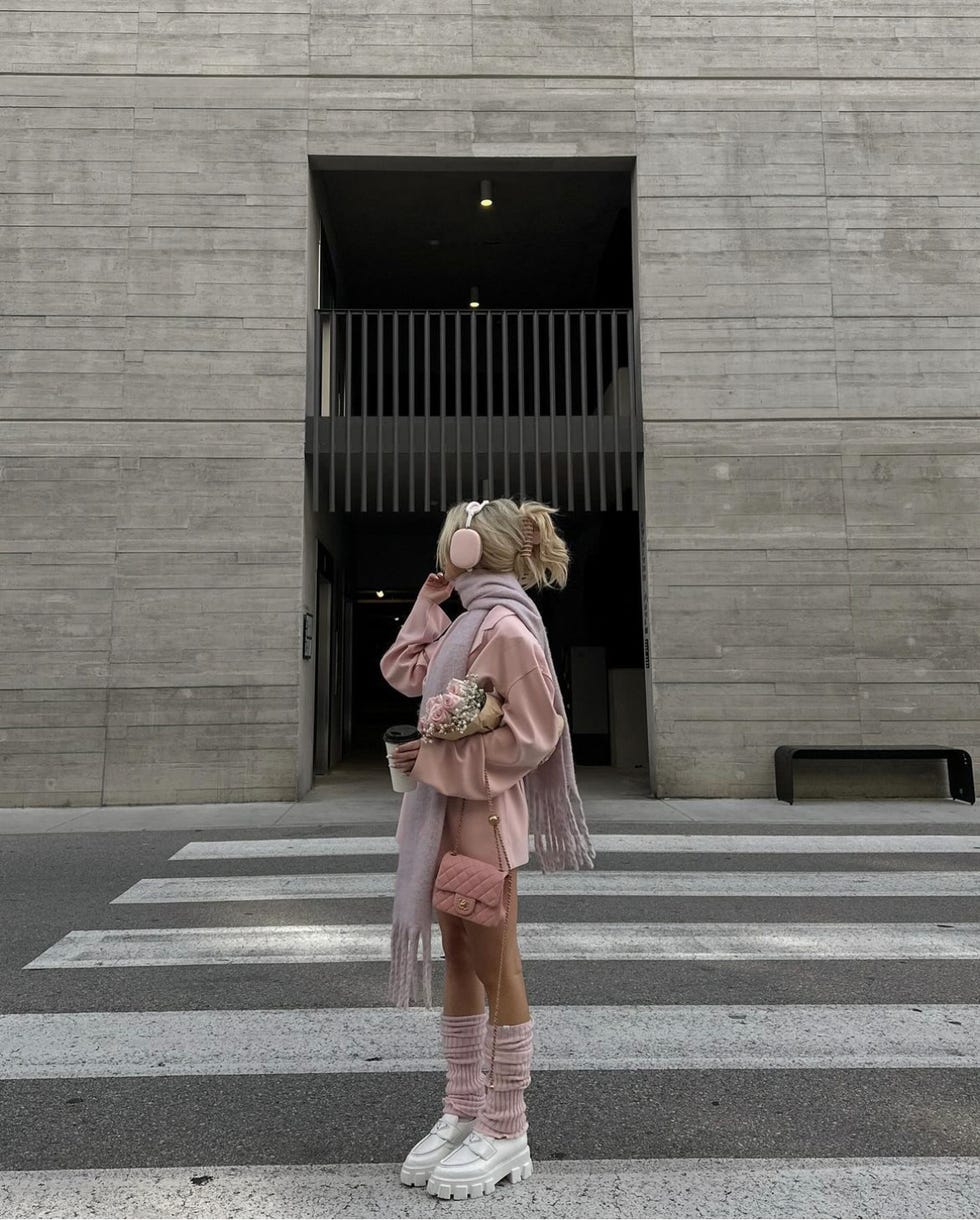 a woman kissing another woman on the cheek in front of a building