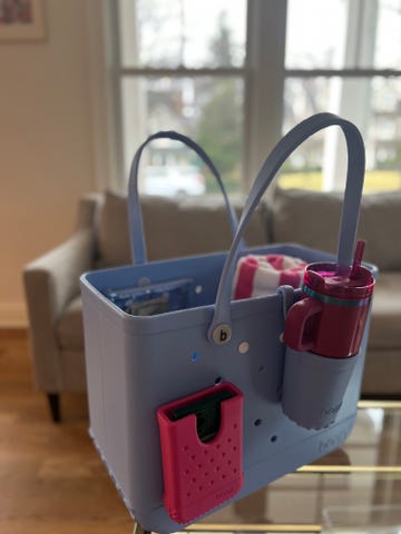 large blue bogg bag with various accessories on a table