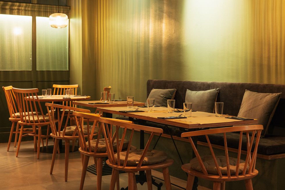 salon interior verde con mesas y sillas de bru barcelona