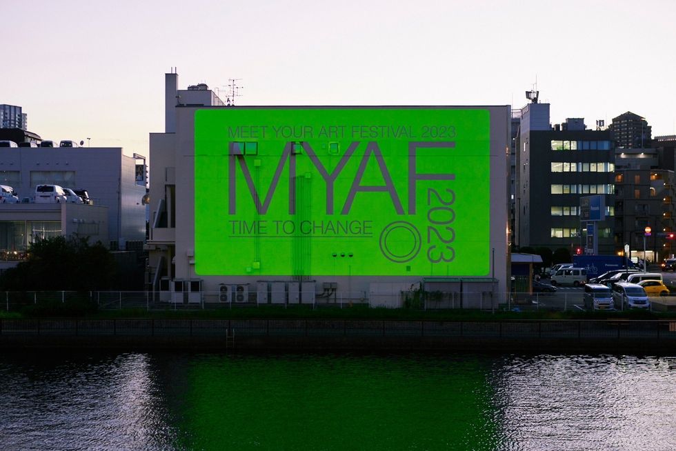 a large green sign next to a body of water