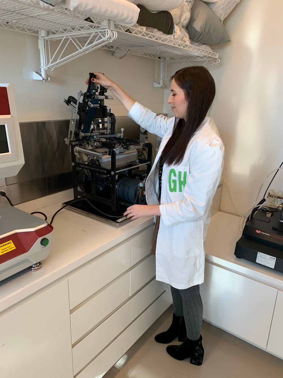 good housekeeping institute senior textile analyst, emma seymour, loading fabric luggage swatches through an abrasion tester machine