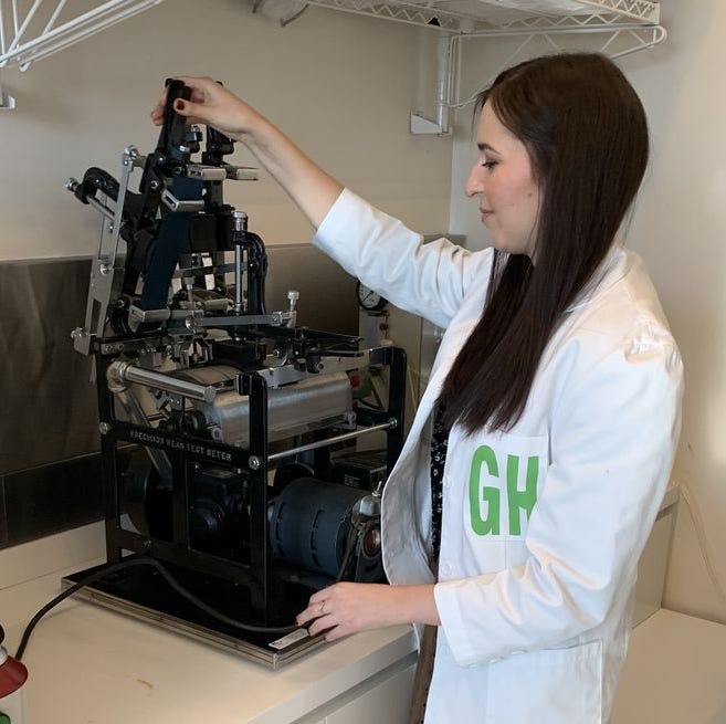 Best Travel Backpacks - Testing image emma seymour loads samples into the wyzebeck abrasion tester to evaluate fabric durability to find the best travel backpacks