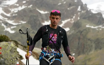 person climbing a mountain with equipment