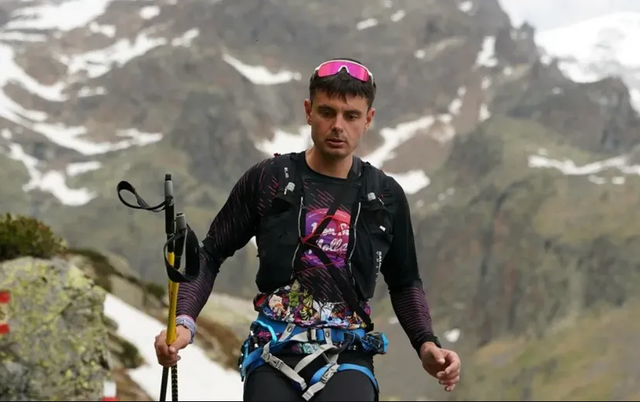 person climbing a mountain with equipment