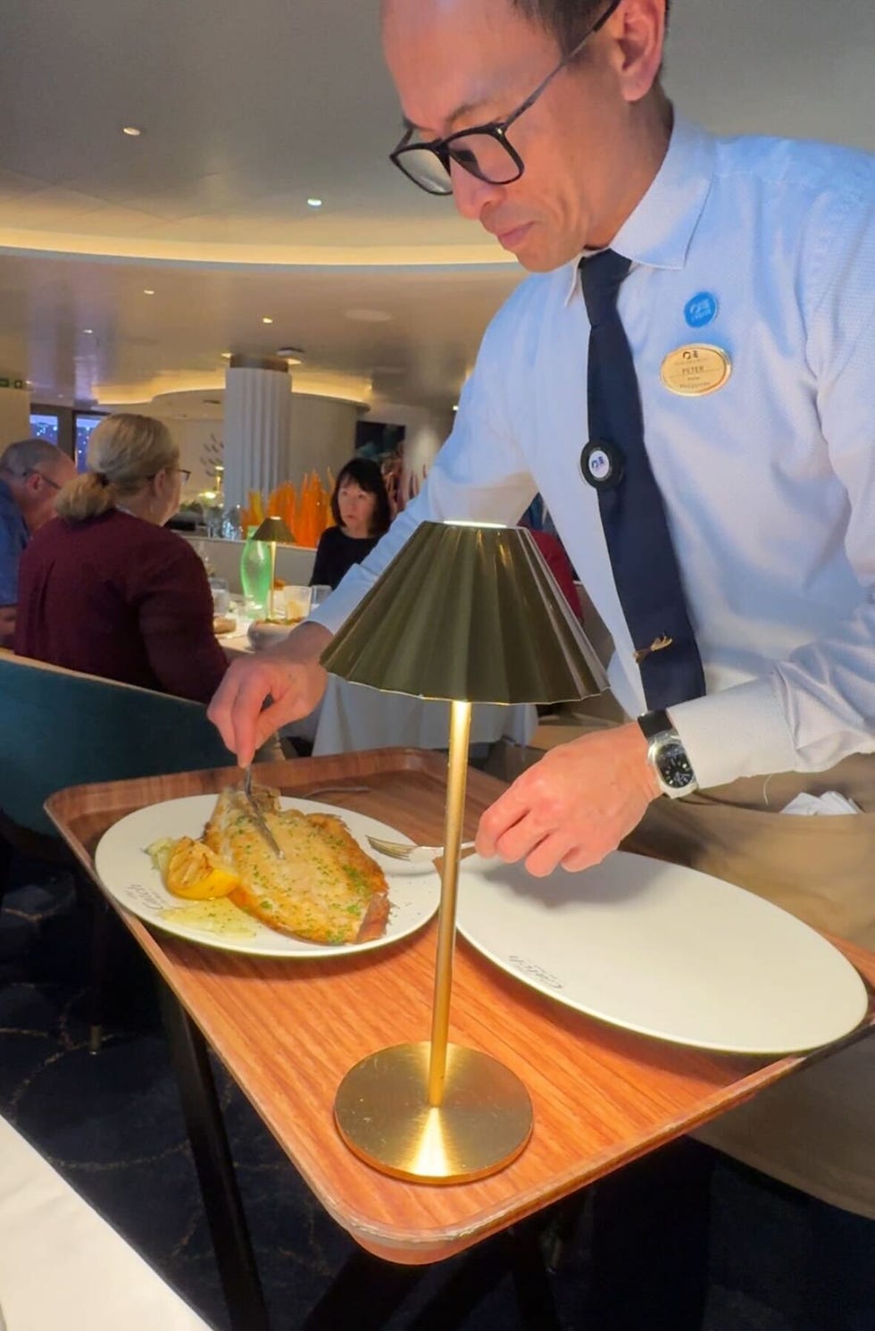 restaurant scene with a waiter serving dover sole