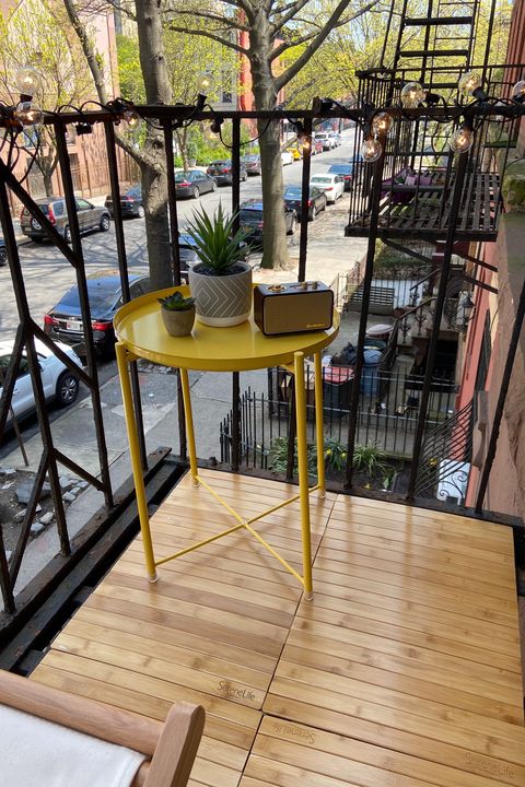 fire escape with wood floor, string lights and yellow table