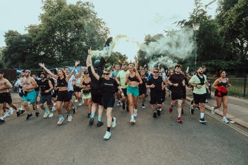 Group of runners participating in a lively event with smoke effects