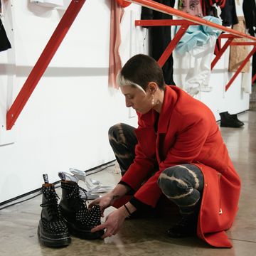 a man kneeling down next to a pair of boots