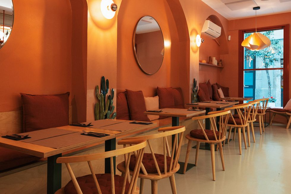 salón interior de bru barcelona con colores calidos mesas y sillas
