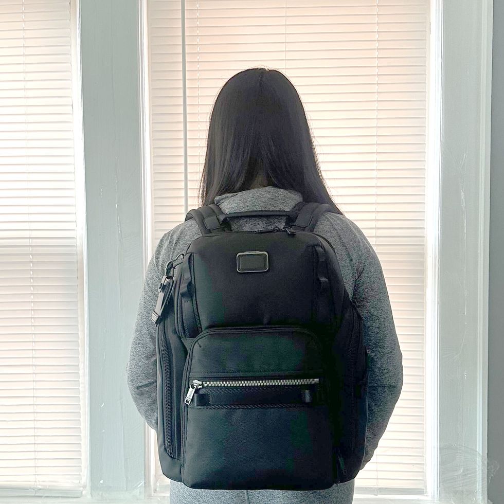 a person wearing the tumi search backpack
