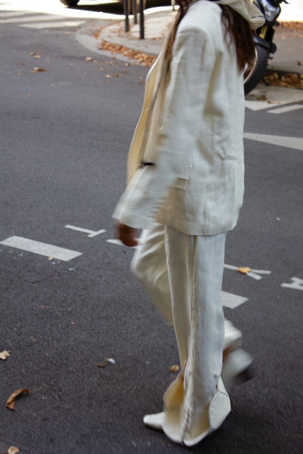 a model walking down a street in a white suit