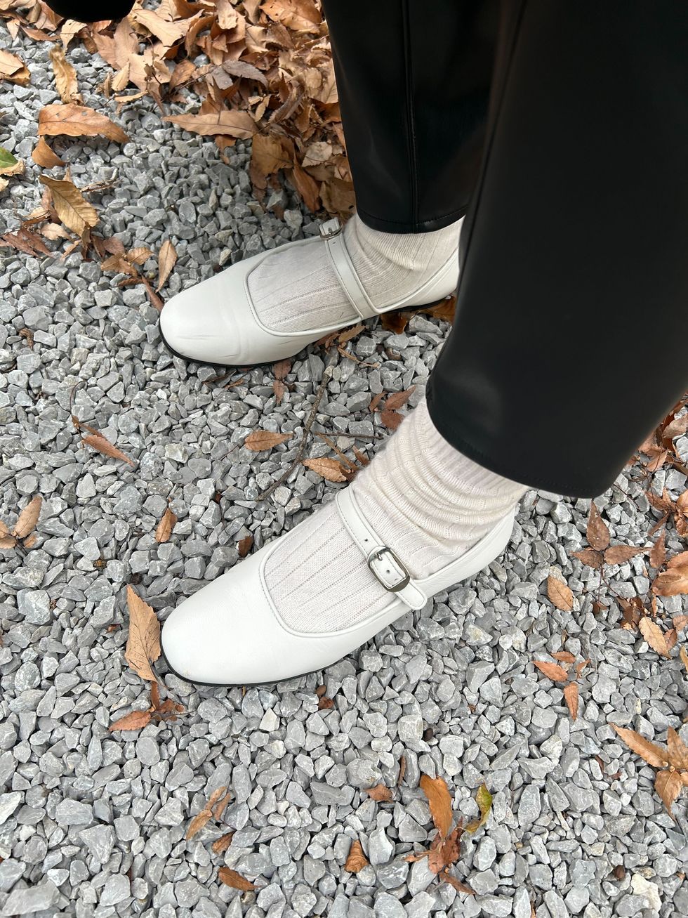 a person's feet in white shoes