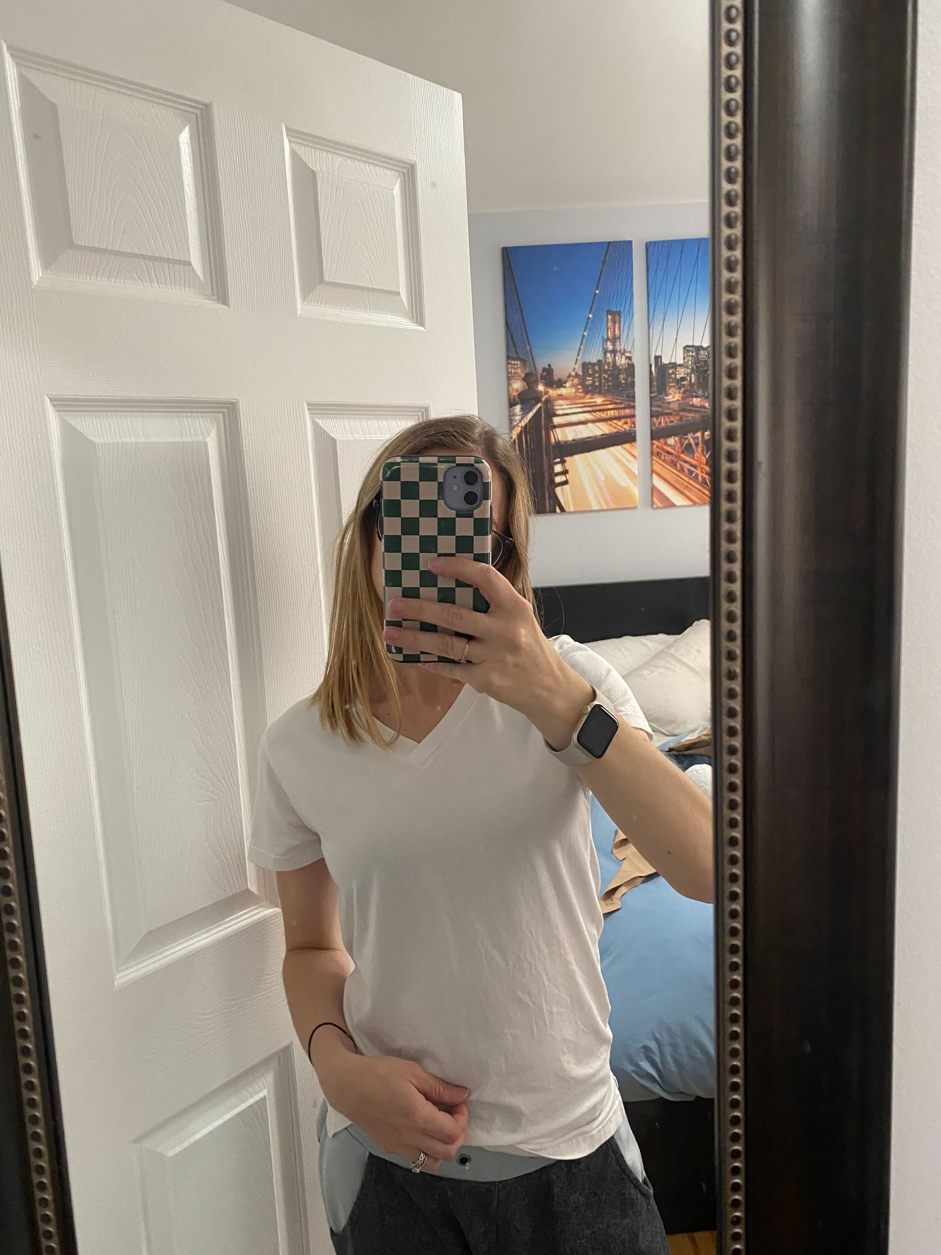 selfportrait in a mirror showing a person wearing a white vneck shirt