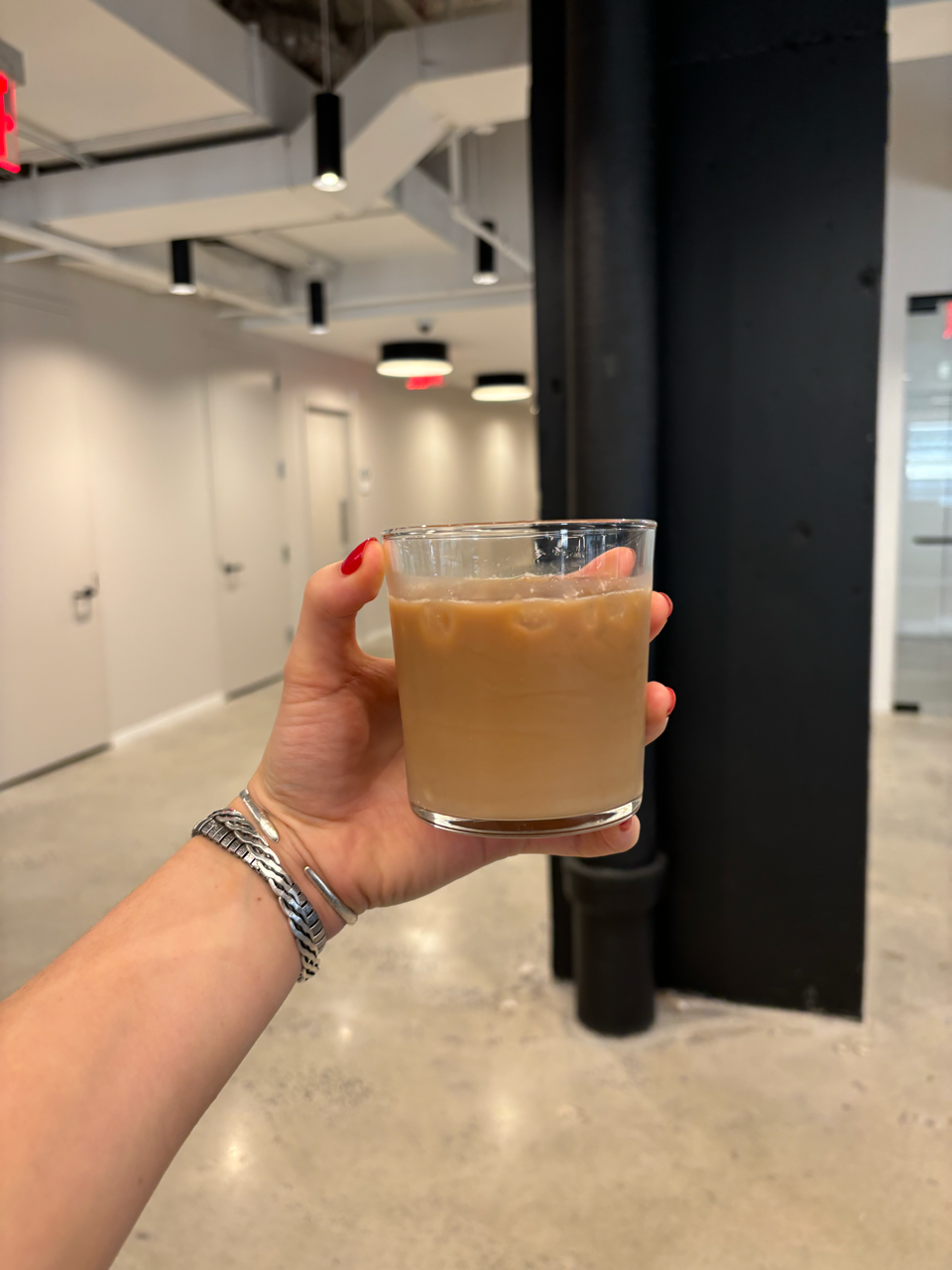 a hand holding a glass of liquid