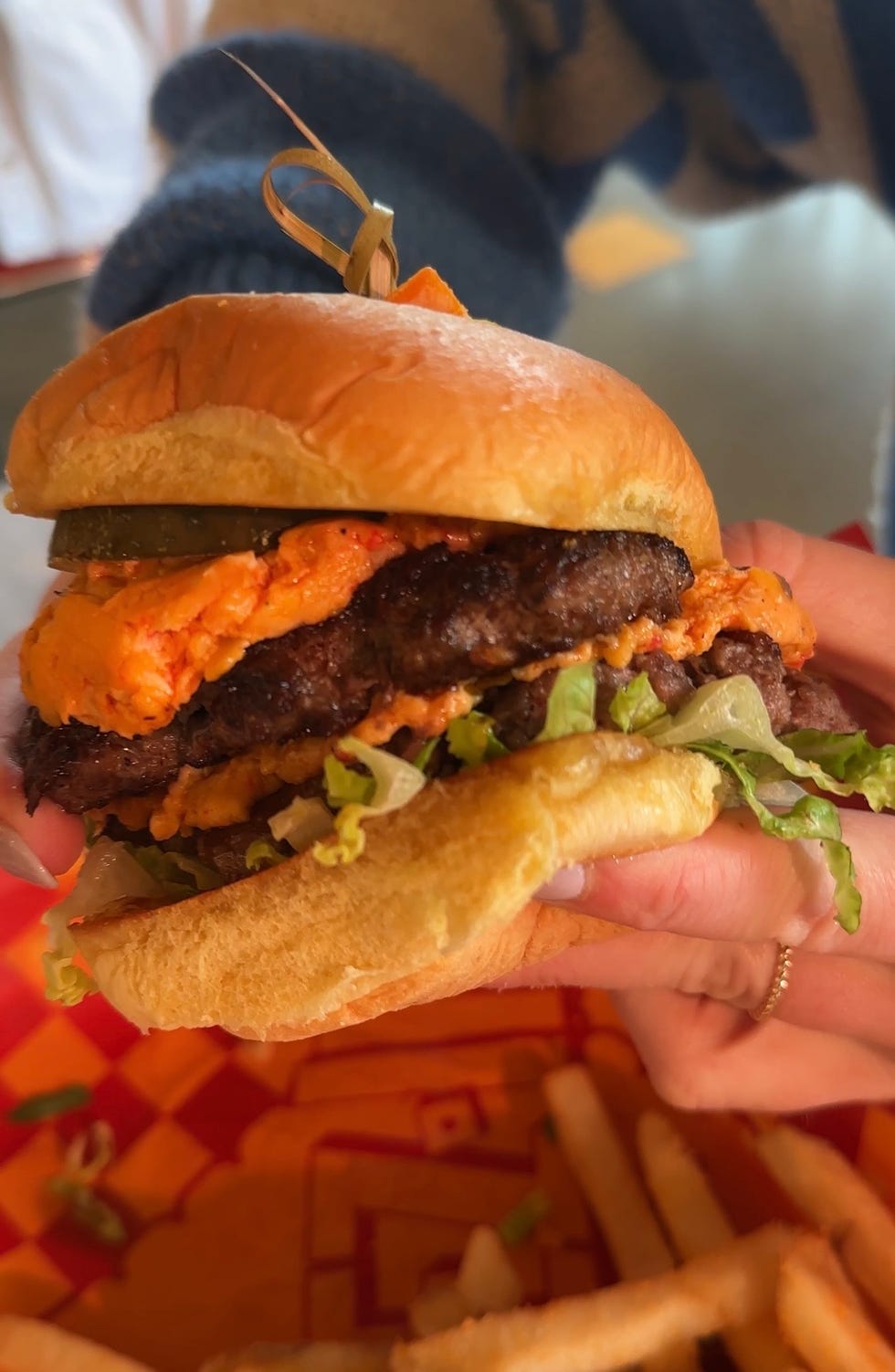 a person holding a burger
