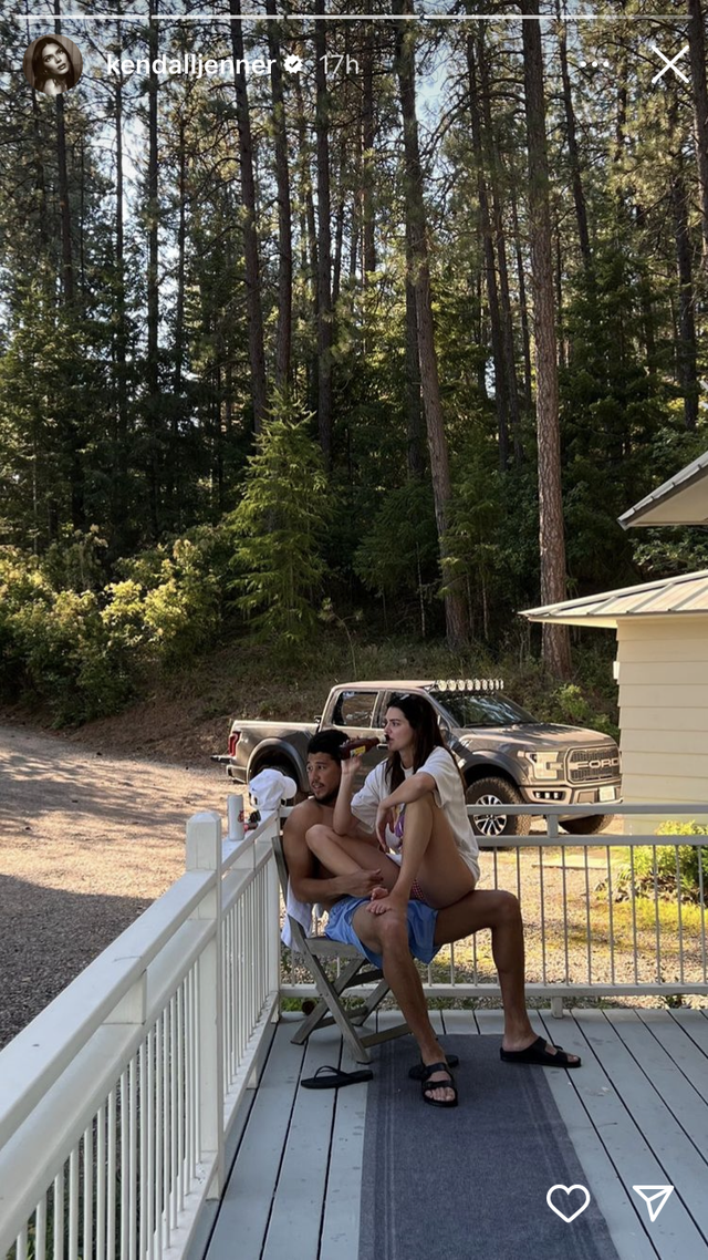 screenshot from kendall jenner's instagram, photo shows her sitting on devin while the two are on a porch in the woods