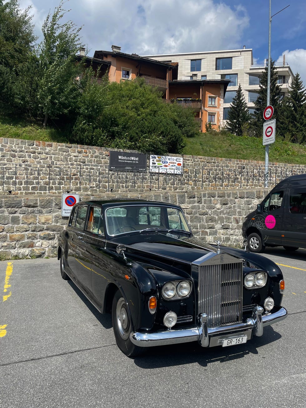 classic black rollsroyce parked in an urban setting with buildings in the background