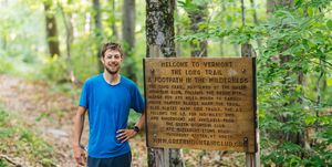 joe mcconaughy stands next to the long trail sign after capturing the unsupported fkt on june 15