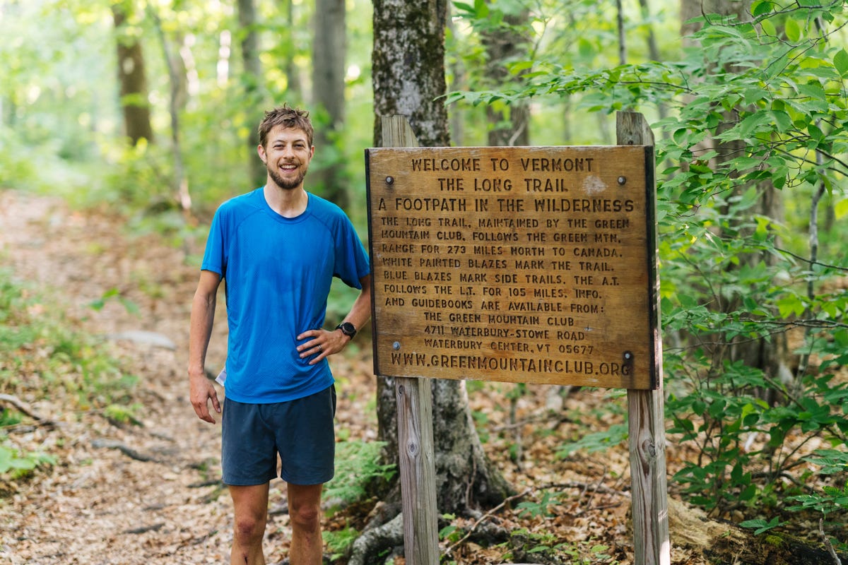 joe mcconaughy stands next to the long trail sign after capturing the unsupported fkt on june 15