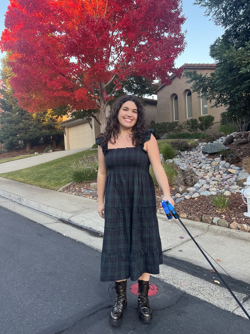 bianca wearing the ellie nap dress outside on the street while holding two dog leashes