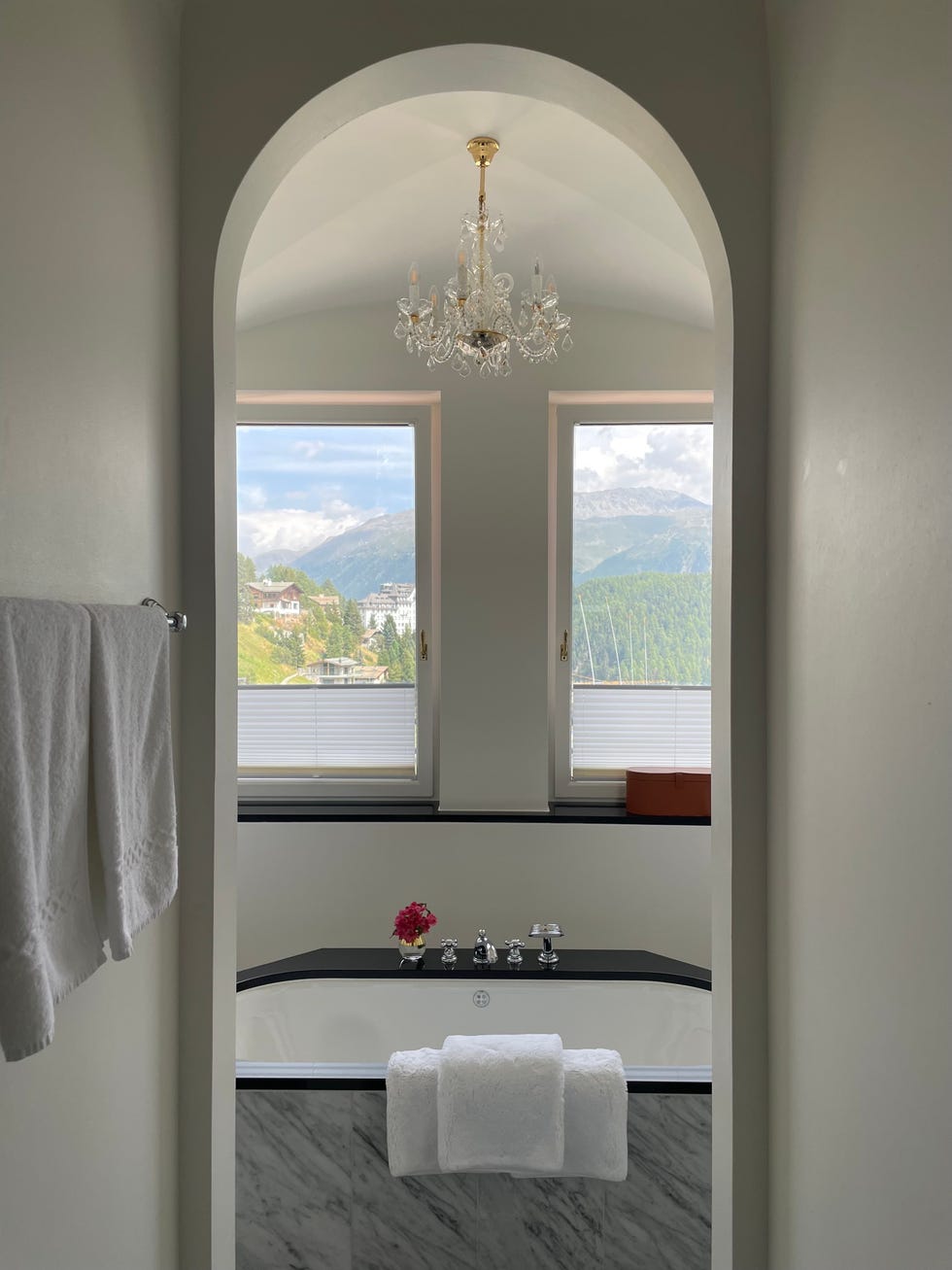 luxurious bathroom with mountain views featuring a chandelier and a bathtub