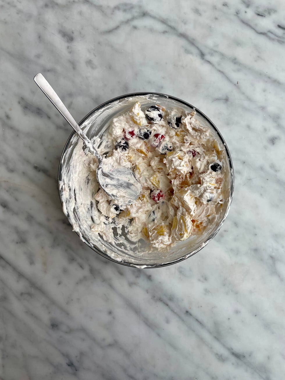 bowl of whipped cream mixed with fruit ingredients