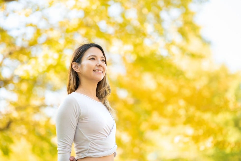 a woman standing in front of yellow flowers