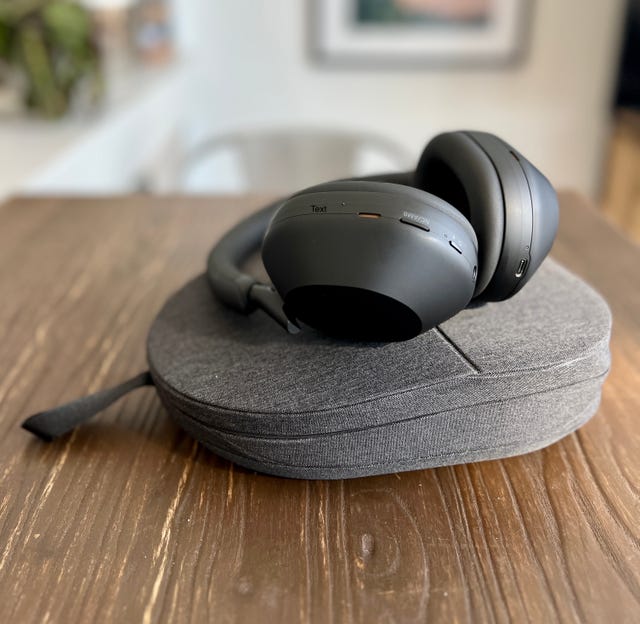a pair of black headphones on a grey carrying case on a table