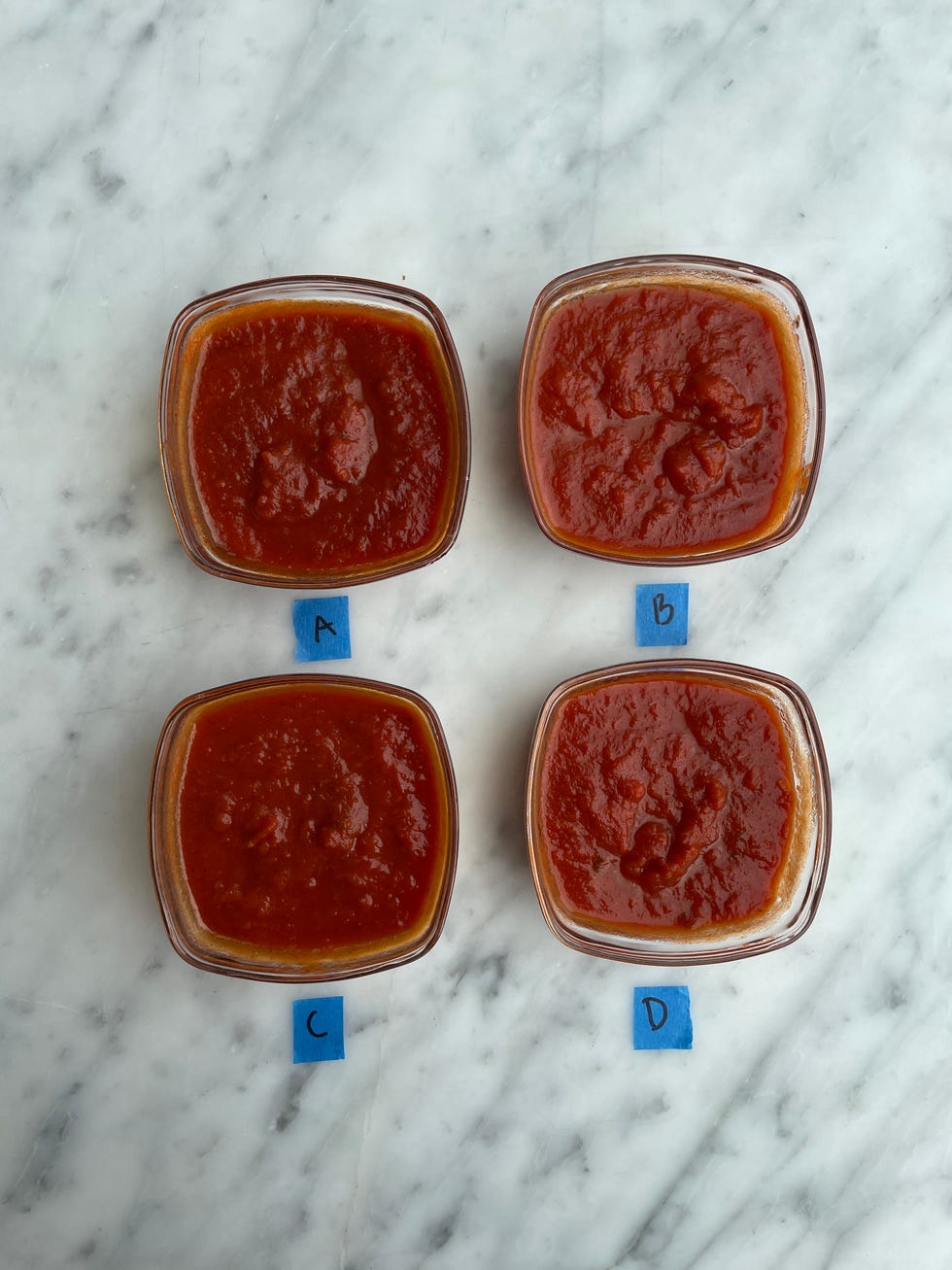 four glass bowls with pasta sauce in each bowl