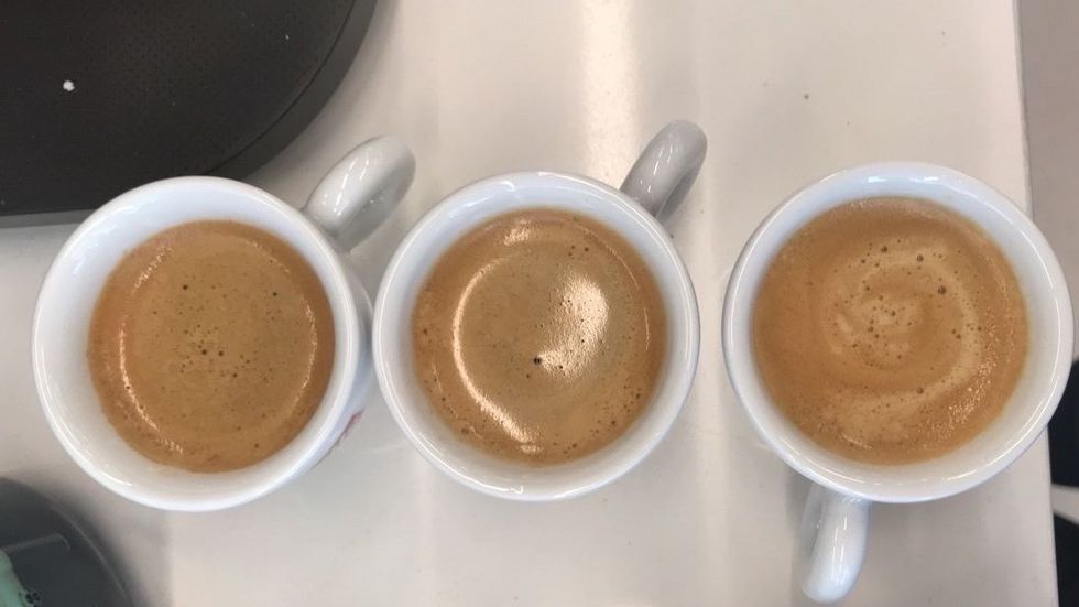 line up of three espresso cups with espresso on a white countertop surface, good housekeeping testing for best nespresso machines