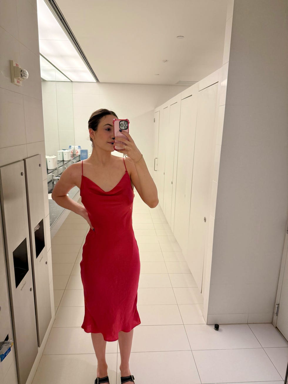 a person wearing a red dress poses in a mirror